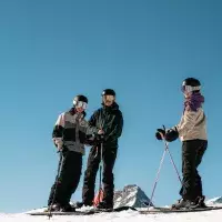 Groupe de skieurs au sommet sous un ciel bleu.