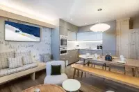 Pièce de vie lumineuse avec cuisine, coin repas et banquettes