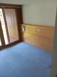 Banquette et habillage mural en bois dans une chambre