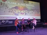 Rencontre avec des invités sur scène lors de l’Xplore Alpes Festival, devant l’écran du festival.