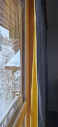 Association de rideaux jaune et gris près d'une fenêtre