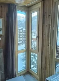 Fenêtre d'angle ouvrant sur les montagnes enneigées