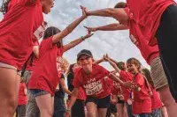 Enfants en t-shirts rouges lors du Hero Game aux Arcs, formant une haie d’honneur autour d’un enfant qui court