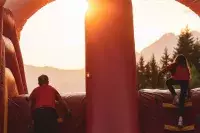 Enfants jouant sur un château gonflable au coucher du soleil