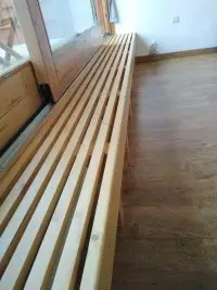 Banquette à lattes en bois le long d'une baie vitrée