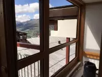 Fenêtre en bois ouverte sur un paysage de montagne