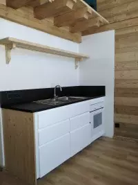 Cuisine compacte blanche et bois avec plan de travail noir