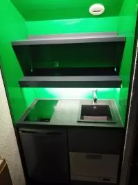 Kitchenette noire intégrée dans une niche verte