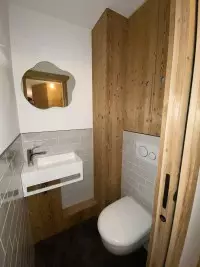 Petite salle d'eau avec porte et habillage en bois