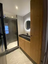 Salle d'eau avec meuble vasque en bois et miroir rond