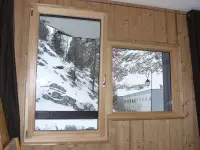 Fenêtres en bois donnant sur un paysage enneigé
