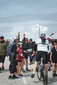 Groupe de cyclistes et spectateurs rassemblés sur la place d’arrivée d’une course.