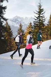 Participants courant dans la neige lors du Les Arcs Star Trail au coucher du soleil