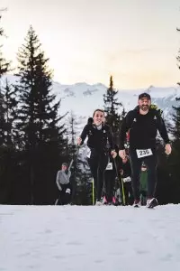 Participants du Les Arcs Star Trail courant sur un parcours enneigé face aux montagnes
