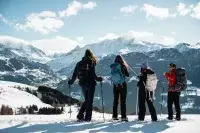 Randonneurs en raquettes face aux montagnes enneigées des Arcs