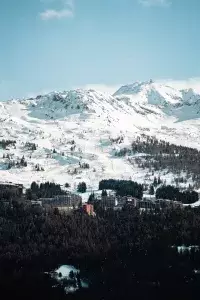 Panorama hivernal sur Arc 1800 avec les pistes de ski et les montagnes environnantes.