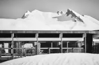 Bâtiment intégré au paysage enneigé des Arcs avec les montagnes en arrière-plan.