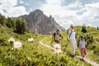 Famille marchant sur un sentier avec panorama alpin.