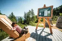 Enfant se reposant face aux montagnes et à un espace ludique.