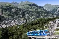 Funiculaire bleu des Arcs traversant la vallée en été.