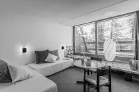 Intérieur d’un appartement de montagne avec vue sur les arbres enneigés.