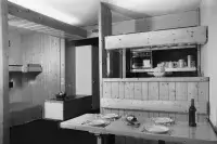 Studio de montagne avec mobilier en bois et coin repas convivial.