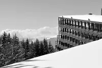 Bâtiment de l’architecture des Arcs intégré dans un paysage enneigé de montagne.