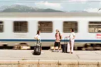 Voyageurs attendant un train en station de montagne.