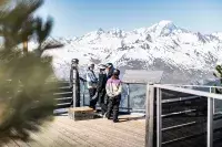Skieurs admirant les sommets enneigés depuis un belvédère.