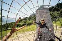 Enfant jouant dans une structure filet en montagne.