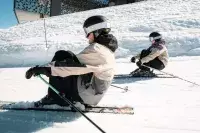 Skieurs assis dans la neige près du télésiège Transarc.