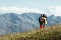 Participant ramassant des déchets en montagne face aux sommets.