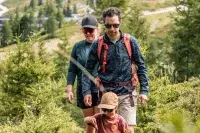 Famille en randonnée dans une forêt de montagne.