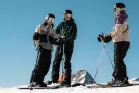 Groupe de skieurs au sommet sous un ciel bleu.
