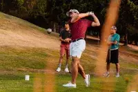Golfeur réalisant un drive sur un parcours alpin.