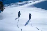 Deux skieurs avancent dans une neige vierge en montagne.