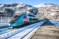 Train OUIGO à quai entouré de montagnes enneigées