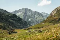 Vue panoramique sur une vallée alpine verdoyante.