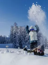 Enfants jouant dans la neige au cœur d’une forêt enneigée aux Arcs.