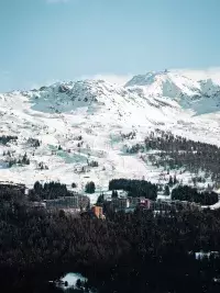 Panorama hivernal sur Arc 1800 avec les pistes de ski et les montagnes environnantes.