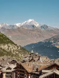 Toits d’un village alpin avec vue sur le massif du Mont Blanc.