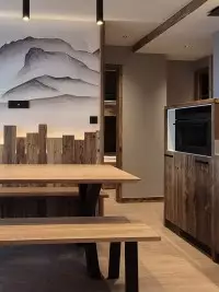 Cuisine et salle à manger en bois avec fresque de montagnes