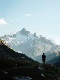 Randonneur admirant les montagnes depuis les hauteurs des Chapieux.