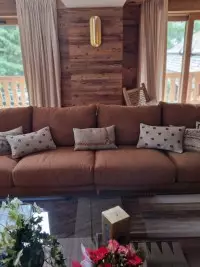 Grand canapé brun décoré de coussins dans un chalet