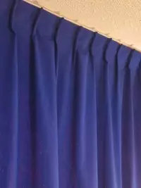 Détail d'un rideau bleu à plis simples