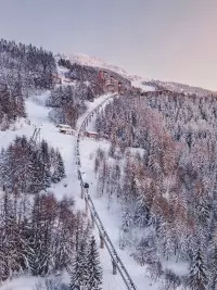 Funiculaire des Arcs traversant une forêt enneigée entre Bourg-Saint-Maurice et Arc 1600.