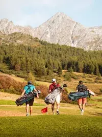 Golfeurs sur le parcours du Golf des Arcs face aux montagnes