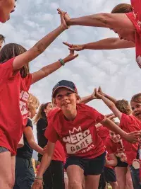 Enfants en t-shirts rouges lors du Hero Game aux Arcs, formant une haie d’honneur autour d’un enfant qui court