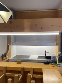 Éclairage sous meuble installé dans une kitchenette en bois