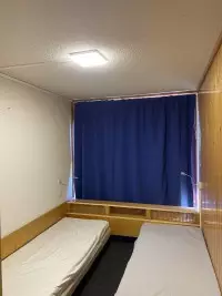 Chambre avec rideau bleu et éclairage de plafond